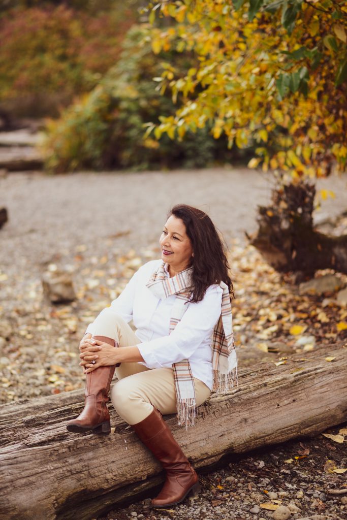 White button down blouse with a cream scarf and leather boots. 